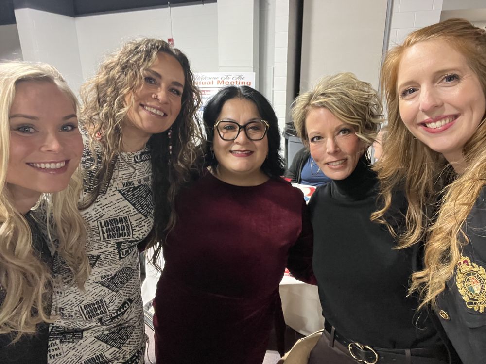 Julia smiling in a group selfie with four women